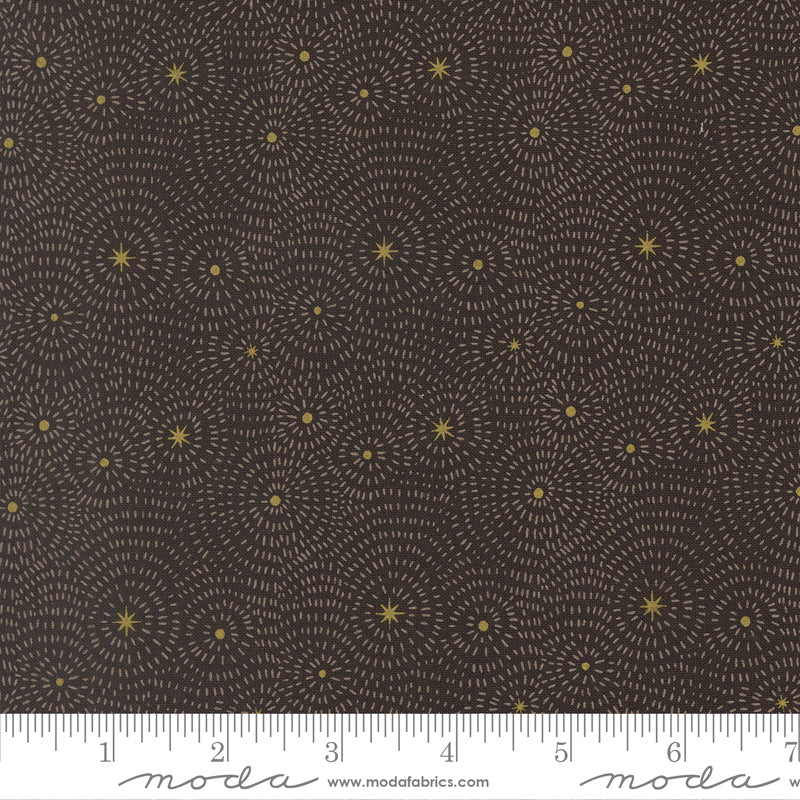 Fabric pattern with starburst design on a dark background, featuring Moda label at the bottom and ruler for scale.