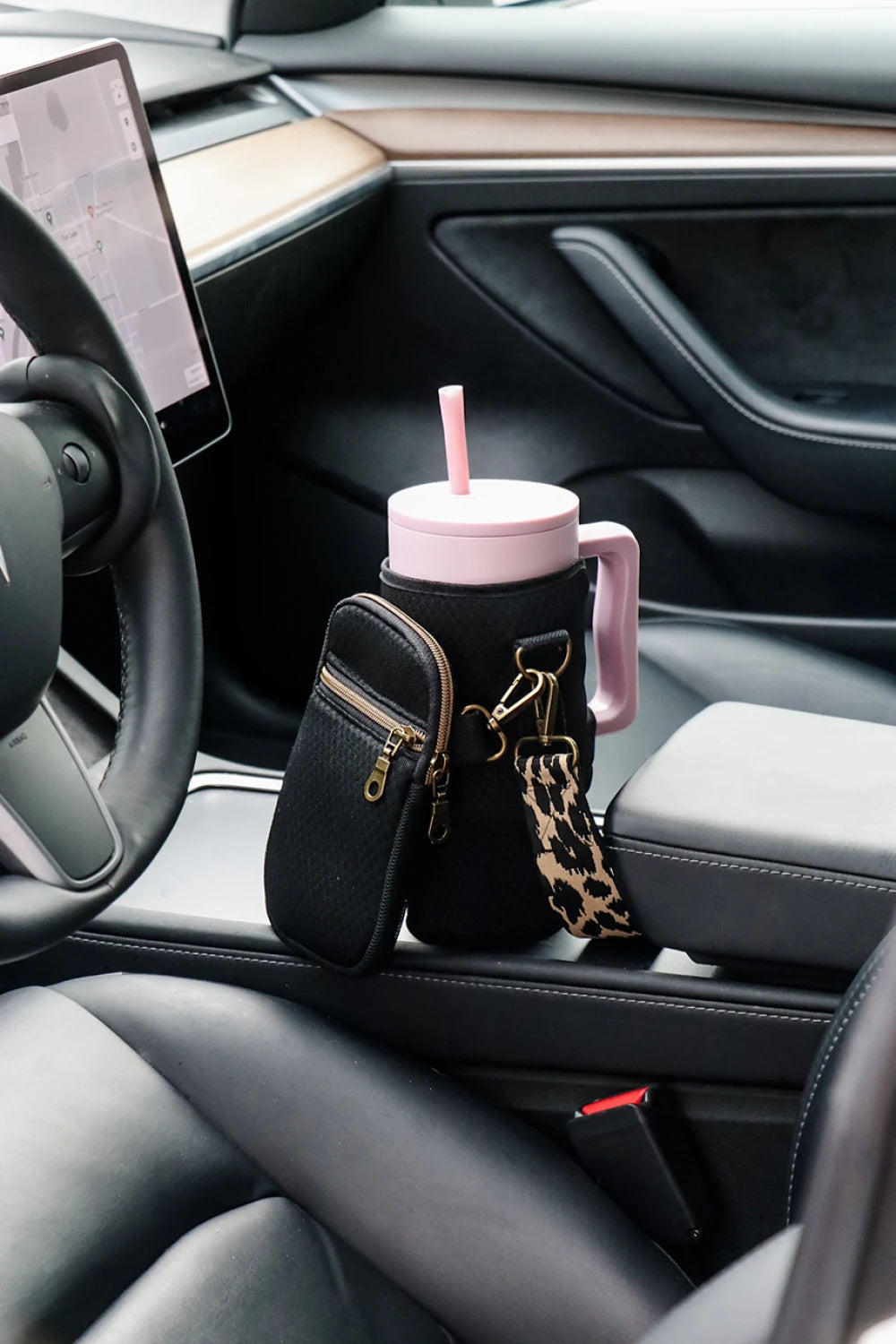 Black sample with a pink water bottle on a car seat