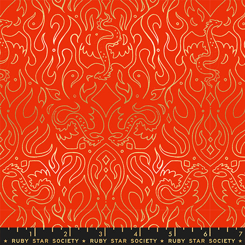 Fabric pattern with gold line art of dragons and flames on a red background with a ruler for scale.