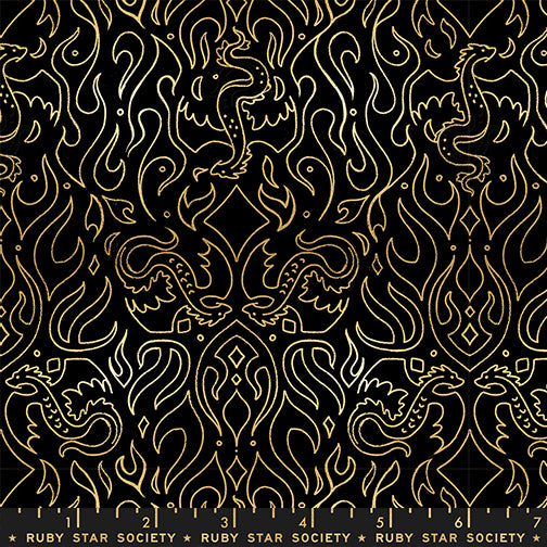 Fabric pattern with gold line art of dragons and flames on a black background with a ruler for scale.