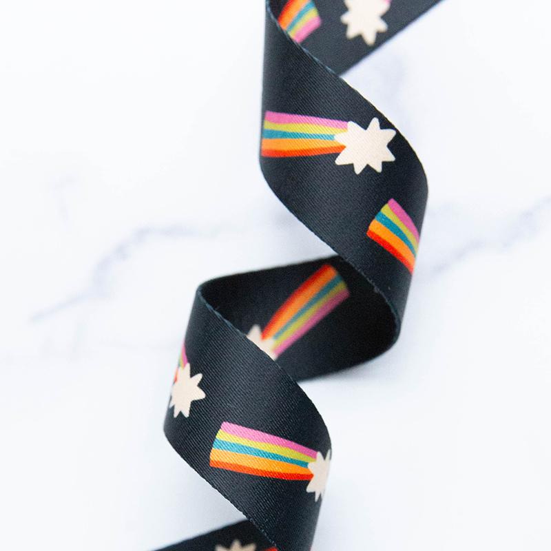 Black webbing with a shooting star and rainbow tail pattern