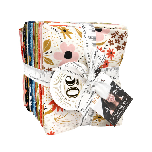Pack of Night Owl fat quarters with floral patterns and a ruler, tied together with a white ribbon.