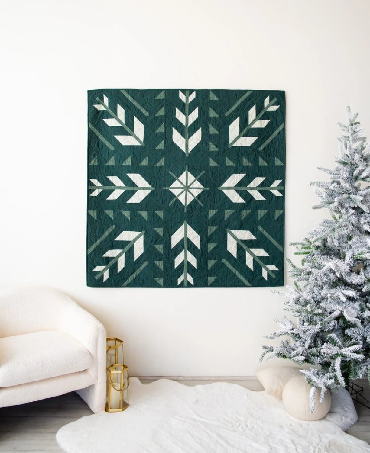 Photo of the finished Artemis quilt hanging on a wall next to an artificial Christmas tree.