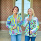 Two women wearing colorful Bell Quilt Coats standing in front of a brick building.