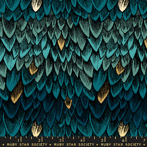 Fabric with a blue tonal dragon scale pattern, with accents of metallic gold scales and a ruler for scale.