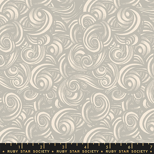 Patterned fabric with swirling designs in gray and white on a gray background with a ruler for scale.